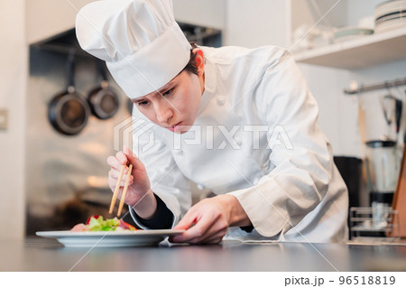 料理の盛り付けをする男性シェフ 96518819