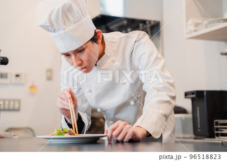 料理の盛り付けをする男性シェフ 96518823