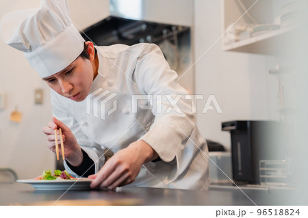 料理の盛り付けをする男性シェフ 96518824