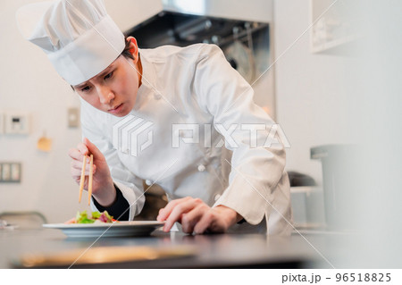 料理の盛り付けをする男性シェフ 96518825