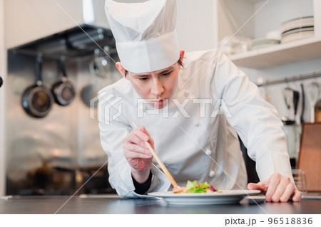 料理の盛り付けをする男性シェフ 96518836