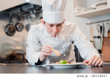 料理の盛り付けをする男性シェフ 96518837