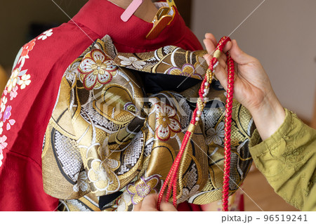 若い女性に振袖の着付けしているところ 若い女性に振袖の着付けしているところ 96519241