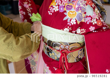 若い女性に振袖の着付けしているところ 若い女性に振袖の着付けしているところ 96519281