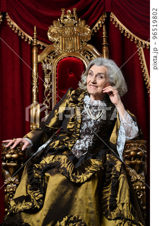 senior queen in a dress sits on a throne senior queen in a dress sits on a throne 96519802