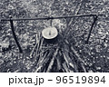 Black and white retro. Cooking in old sooty cauldron on campfire at glade 96519894
