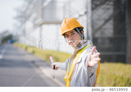 交通誘導をする作業着姿の男性 96519950