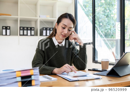 Attractive asian woman accountant working with computer and calculator for business and financial expense Attractive asian woman accountant working with computer and calculator for business and financial expense 96520999