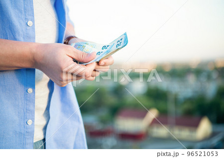 Man crop view counting cash money banknotes blur outdoors, copy space Man crop view counting cash money banknotes blur outdoors, copy space 96521053