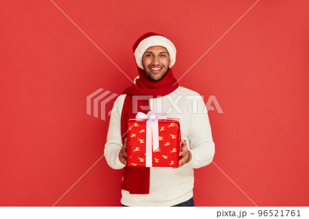 Happy Man Holding Present. Multiracial Guy in Santa Hat Holding Present Box 96521761