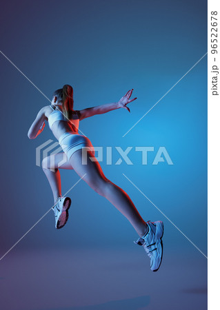 Back view of young sportive girl in white sportswear running away isolated over gradient blue purple background in neon light. Fitness, hobby, healthy lifestyle Back view of young sportive girl in white sportswear running away isolated over gradient blue purple background in neon light. Fitness, hobby, healthy lifestyle 96522678