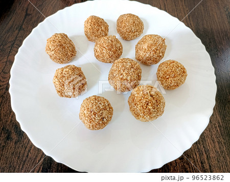Indian white sesame seeds sweet or tilgul laddu, made up of jaggery and sesame seeds, hand made, round, indian sweet on Makar Sankranti festival Indian white sesame seeds sweet or tilgul laddu, made up of jaggery and sesame seeds, hand made, round, indian sweet on Makar Sankranti festival 96523862