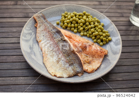 Fried trout fillets served with green peas Fried trout fillets served with green peas 96524042