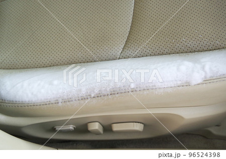 乗用車の本革シートのメンテナンスでクリーナーの泡を吹きつけた状態 96524398