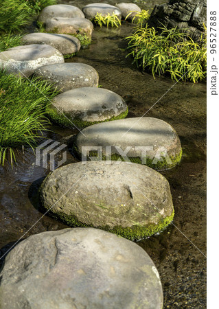 水ぬるむ流れのある池の上に置かれた丸い飛び石・後楽園 水ぬるむ流れのある池の上に置かれた丸い飛び石・後楽園 96527888
