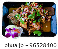 Fried fish decorated with beautiful vegetables on a black plate 96528400