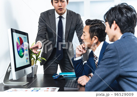 パソコン画面を見ながら会議するビジネスマン 96529009