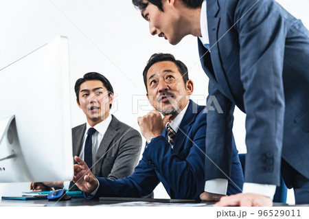 パソコン画面を見ながら会議するビジネスマン パソコン画面を見ながら会議するビジネスマン 96529011