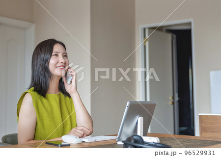 自宅で仕事をする若い女性　スマホで連絡 96529931