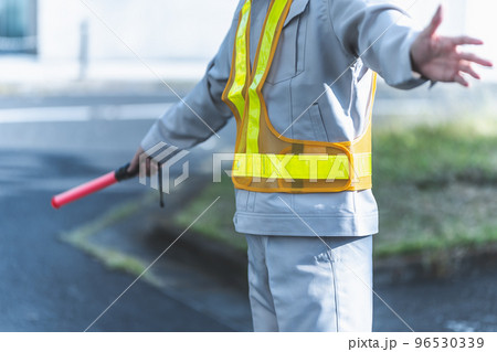 交通誘導をする作業着姿の男性 96530339