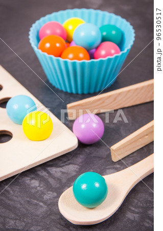 Colorful balls with spoon and tongs. Development of kids motor skills 96530517