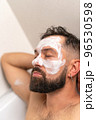 man with face mask relaxing in bath at home 96530598