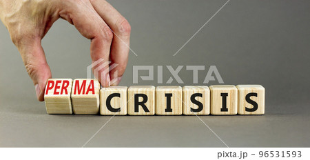 Permacrisis or crisis symbol. Concept words Crisis and Permacrisis on wooden cubes. Businessman hand. Beautiful grey table grey background. Business permacrisis or crisis concept. Copy space. 96531593