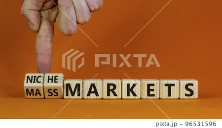 Mass or niche markets symbol. Businessman turns wooden cubes and changed words 'mass markets' to 'niche markets'. Beautiful orange background, copy space. Business and mass or niche markets concept. Mass or niche markets symbol. Businessman turns wooden cubes and changed words 'mass markets' to 'niche markets'. Beautiful orange background, copy space. Business and mass or niche markets concept. 96531596