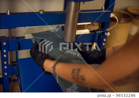 Employee in gloved hands using the coffee sealing equipment 96532286