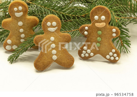 gingerbread man cookies decorated with royal icing, with icing sugar and fir branh on white background. Christmas food, pastry background. New Year theme. Merry Christmas and Happy New Year Holidays gingerbread man cookies decorated with royal icing, with icing sugar and fir branh on white background. Christmas food, pastry background. New Year theme. Merry Christmas and Happy New Year Holidays 96534758