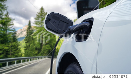 Progressive electric car in the green forest with charging station concept. Progressive electric car in the green forest with charging station concept. 96534871