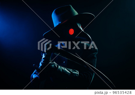 Plague doctor with sharp scythe on black smoke background. Creepy raven mask, halloween, historical 96535428