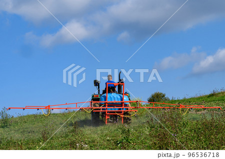 A tractor with a tank and attached equipment for spraying the field from pests and weeds, the process of processing the field. A tractor with a tank and attached equipment for spraying the field from pests and weeds, the process of processing the field. 96536718