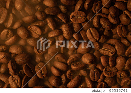 The texture of freshly roasted, ready-to-drink coffee, steam rising above the beans, black ava beans. The texture of freshly roasted, ready-to-drink coffee, steam rising above the beans, black ava beans. 96536741