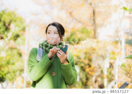コートとマスクの女性　スマホ 96537127
