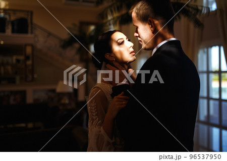 Young married couple in darkness. Newlyweds enjoy each other tenderly. Intimate atmosphere. Romantic moment. 96537950