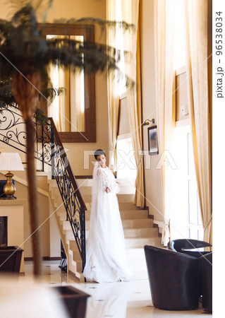 Beautiful bride in fashion wedding dress with a long luxury veil. The stunning young bride is incredibly happy. Beautiful bride in fashion wedding dress with a long luxury veil. The stunning young bride is incredibly happy. 96538034