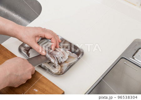 【ミドル主婦がスルメイカをさばく　切ったスルメイカをバットに移す】 96538304