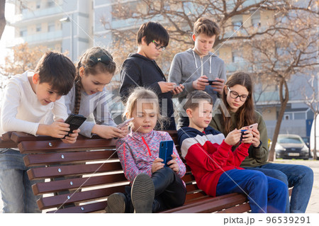 Children are playing on smartphone in the playground 96539291