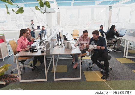Collaborative process of multicultural skilled young business team during brainstorming meeting in office.Diverse group of young people dressed in formal wear cooperating on developing design project 96539797