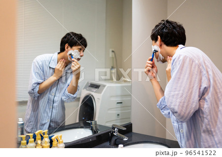 T字カミソリでヒゲ剃りをする40代男性 96541522