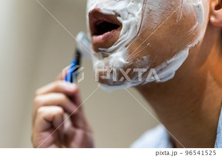 T字カミソリでヒゲ剃りをする40代男性 T字カミソリでヒゲ剃りをする40代男性 96541525