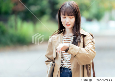パソコンを持って歩く若い女性 96542933