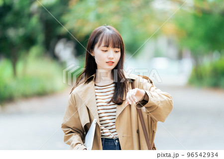 パソコンを持って歩く若い女性 96542934