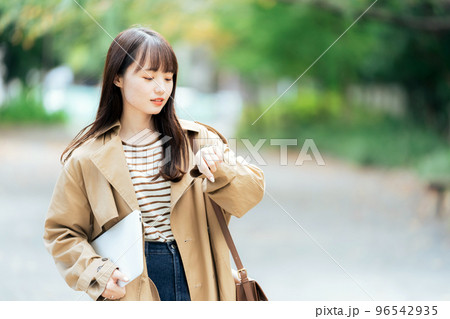 パソコンを持って歩く若い女性 96542935