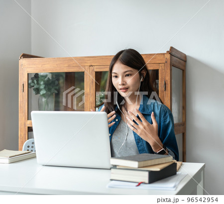 Young woman student in headset is video conference on laptop with classmates and lecturer after finished 96542954