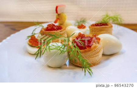 Closeup of caviar and cream cheese appetizer on crackers Closeup of caviar and cream cheese appetizer on crackers 96543270