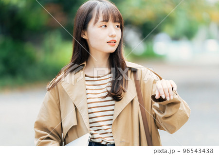 パソコンを持って歩く若い女性 96543438
