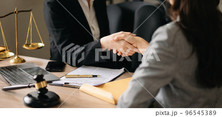 Judge and client shaking hands and lawyers discussing contract papers  after adviced in background at courtroom, lawyer service concept at office 96545389