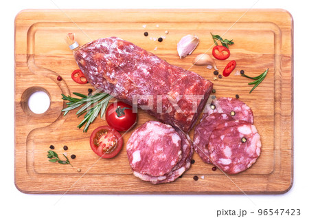 Sliced Smoked dry Salami sausage on wooden cutting board isolated on white background 96547423
